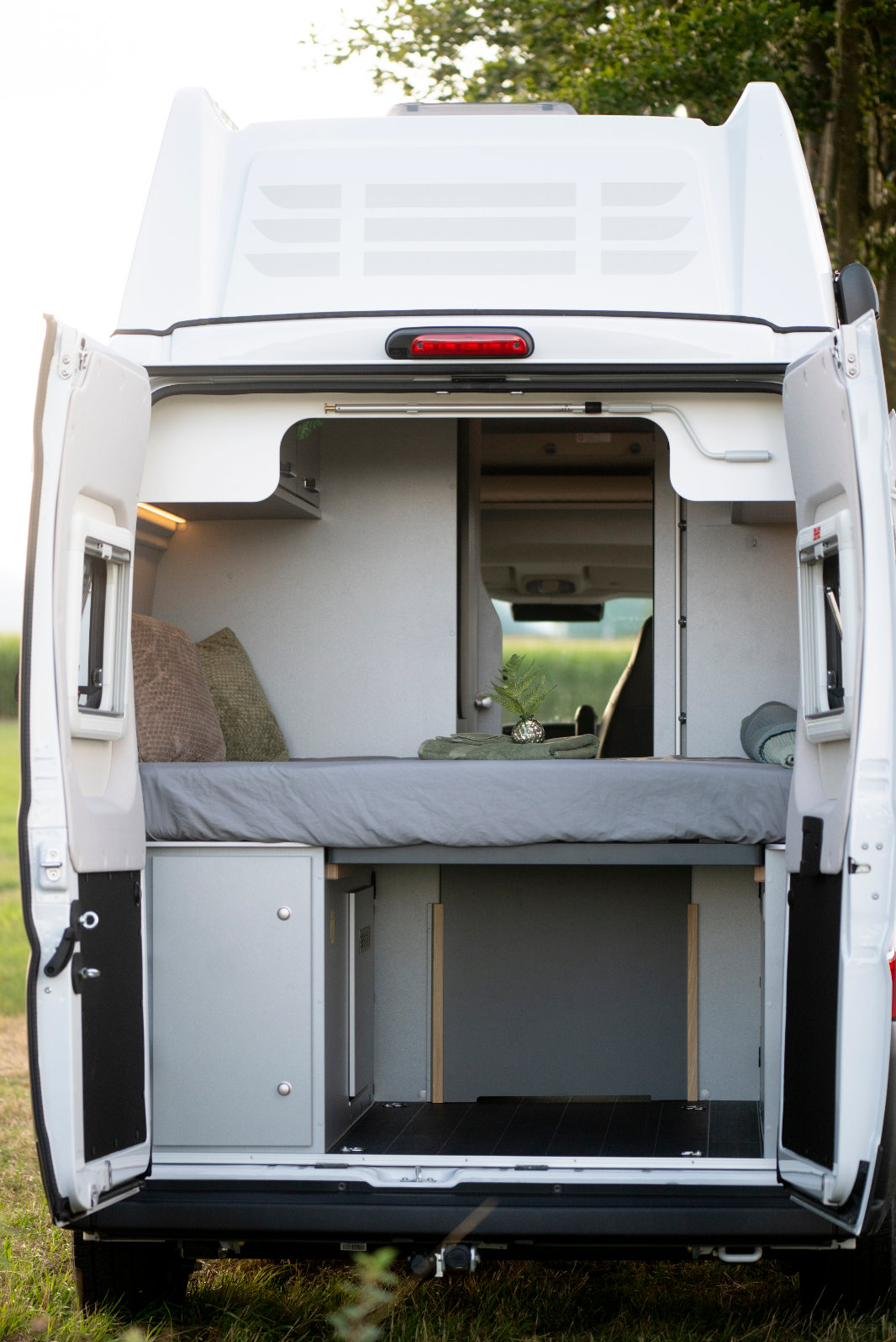 Camper Heckbett mit Stauraum, Blick durch geöffnete Hecktüren