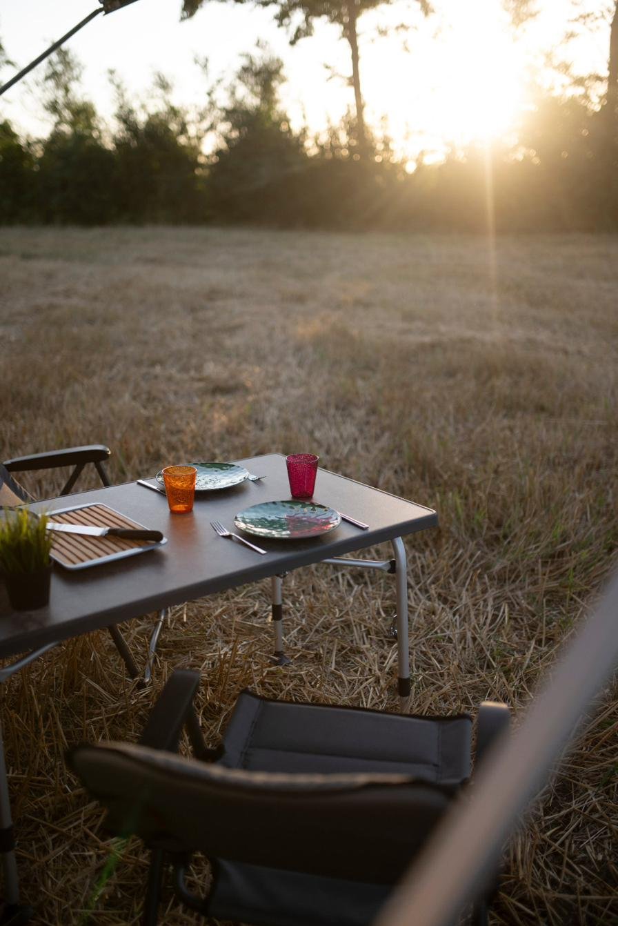 Camping Lifestyle – gedeckter Tisch bei Sonnenuntergang am CaraBus